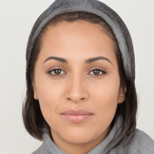 Joyful latino young-adult female with long  brown hair and brown eyes