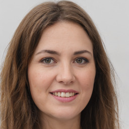 Joyful white young-adult female with long  brown hair and green eyes