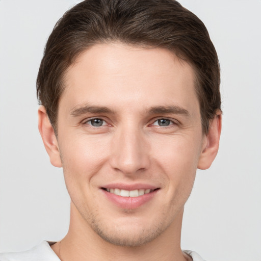 Joyful white young-adult male with short  brown hair and grey eyes