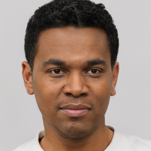 Joyful black young-adult male with short  black hair and brown eyes