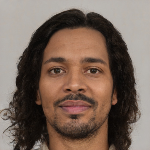 Joyful black young-adult male with medium  brown hair and brown eyes