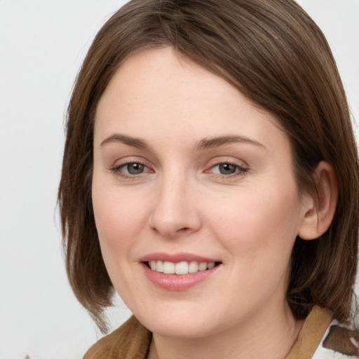 Joyful white young-adult female with medium  brown hair and grey eyes