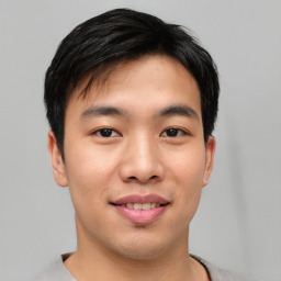 Joyful asian young-adult male with short  black hair and brown eyes