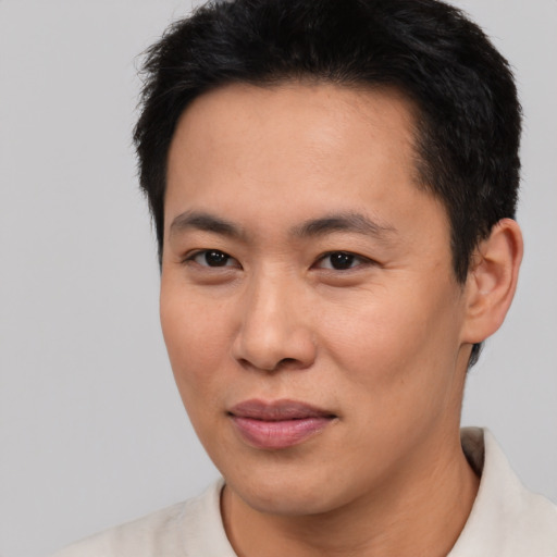 Joyful asian young-adult male with short  brown hair and brown eyes