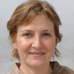 Joyful white young-adult female with medium  brown hair and blue eyes