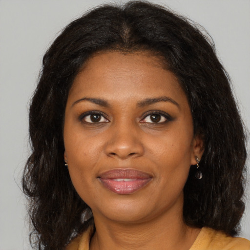 Joyful black young-adult female with long  brown hair and brown eyes