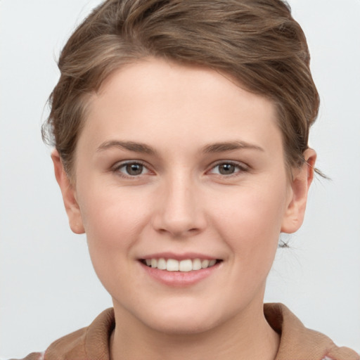 Joyful white young-adult female with short  brown hair and grey eyes