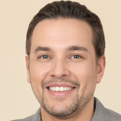 Joyful white young-adult male with short  brown hair and brown eyes