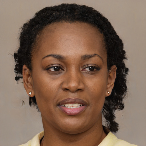 Joyful black adult female with medium  black hair and brown eyes