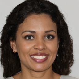 Joyful black young-adult female with medium  brown hair and brown eyes