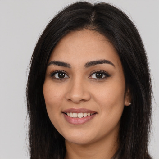 Joyful latino young-adult female with long  brown hair and brown eyes