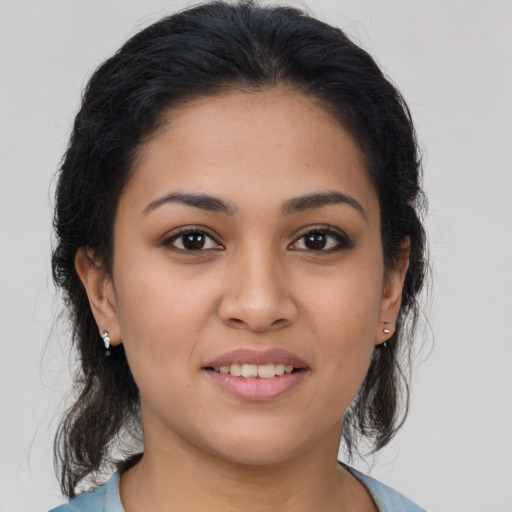 Joyful latino young-adult female with medium  brown hair and brown eyes