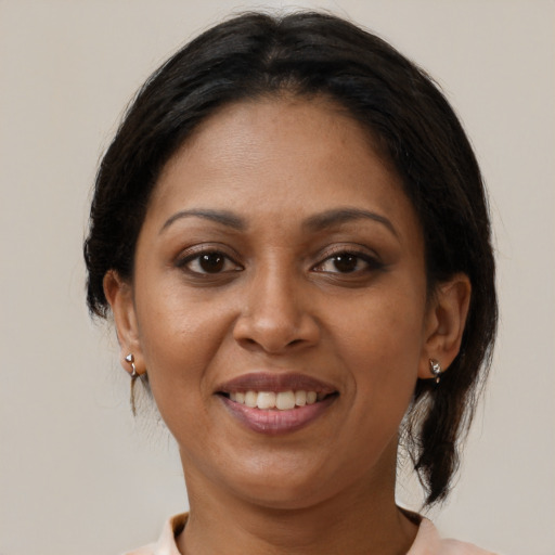 Joyful black adult female with medium  brown hair and brown eyes