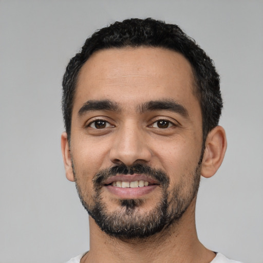 Joyful latino young-adult male with short  black hair and brown eyes