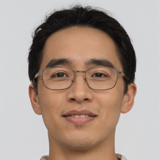 Joyful asian young-adult male with short  brown hair and brown eyes