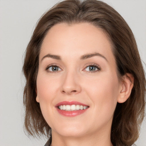 Joyful white young-adult female with medium  brown hair and grey eyes