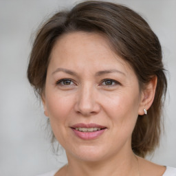 Joyful white adult female with medium  brown hair and grey eyes