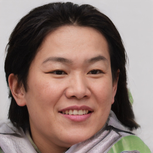 Joyful asian adult female with medium  brown hair and brown eyes
