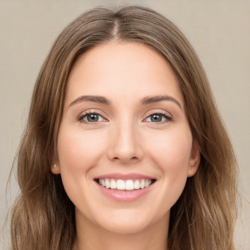 Joyful white young-adult female with long  brown hair and green eyes