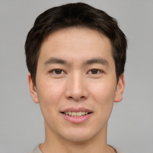Joyful asian young-adult male with short  brown hair and brown eyes