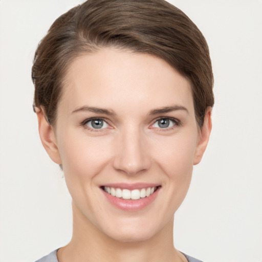 Joyful white young-adult female with short  brown hair and grey eyes