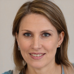 Joyful white adult female with medium  brown hair and brown eyes