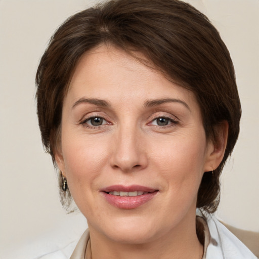 Joyful white adult female with medium  brown hair and grey eyes