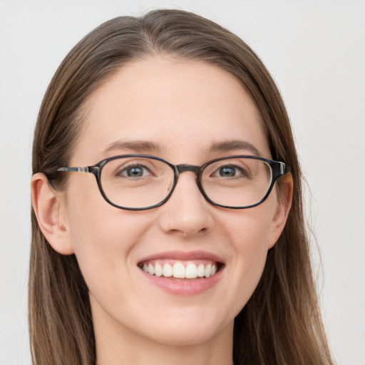 Joyful white young-adult female with long  brown hair and blue eyes