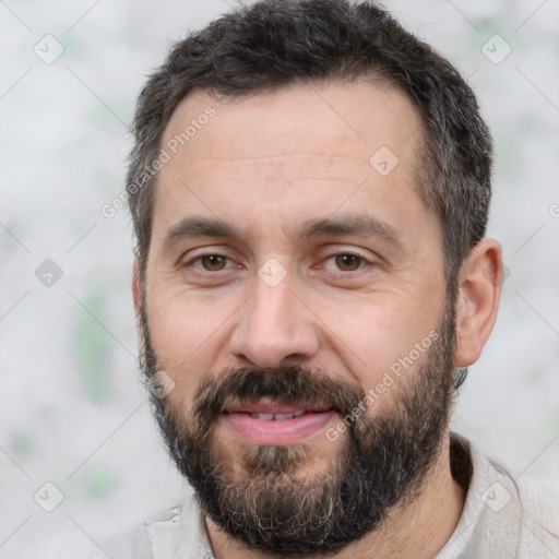 Joyful white adult male with short  black hair and brown eyes