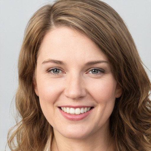 Joyful white young-adult female with long  brown hair and green eyes