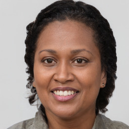 Joyful black adult female with long  brown hair and brown eyes