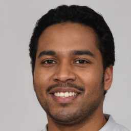 Joyful latino young-adult male with short  black hair and brown eyes