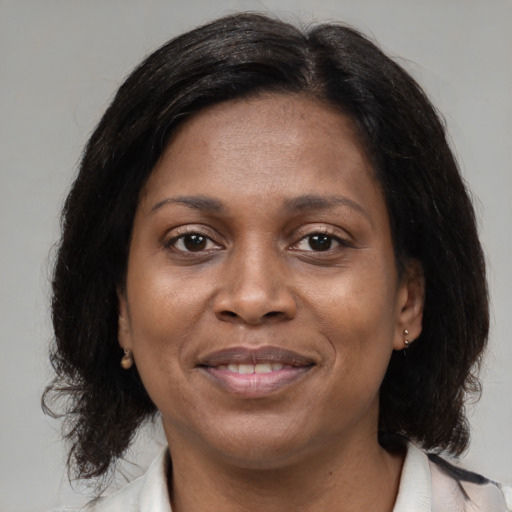 Joyful black adult female with medium  brown hair and brown eyes