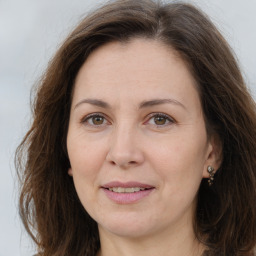 Joyful white adult female with long  brown hair and brown eyes