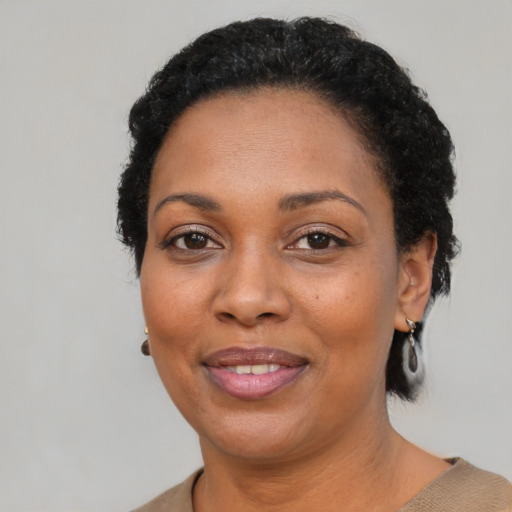 Joyful black adult female with short  black hair and brown eyes