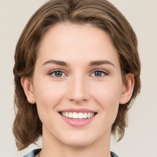 Joyful white young-adult female with medium  brown hair and green eyes