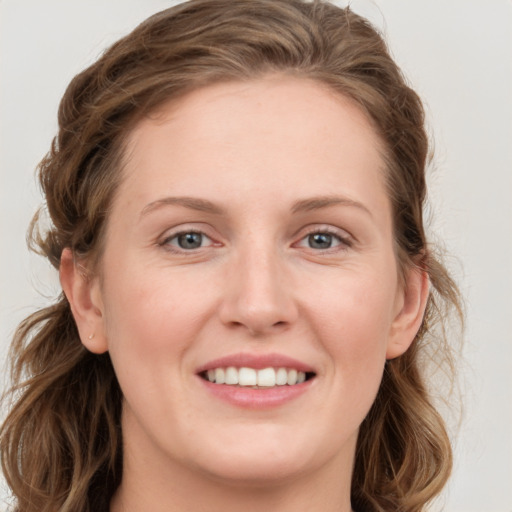 Joyful white young-adult female with long  brown hair and grey eyes