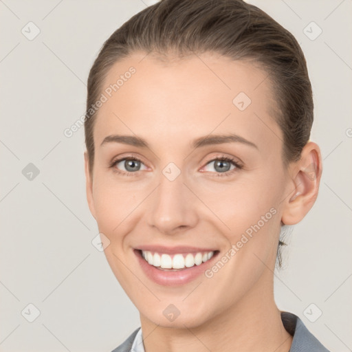 Joyful white young-adult female with short  brown hair and grey eyes