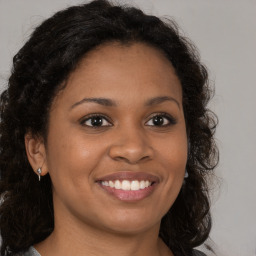 Joyful black young-adult female with medium  brown hair and brown eyes