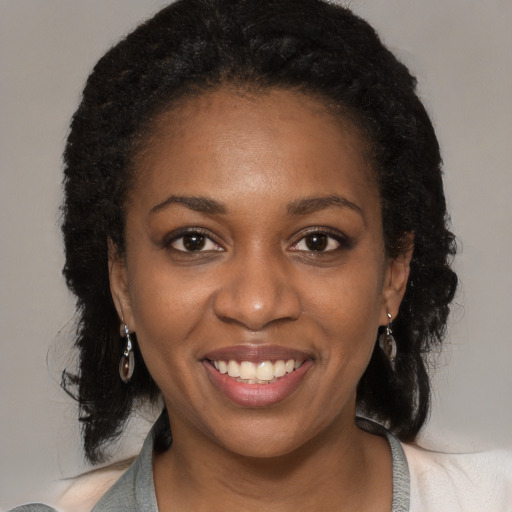 Joyful black young-adult female with long  brown hair and brown eyes