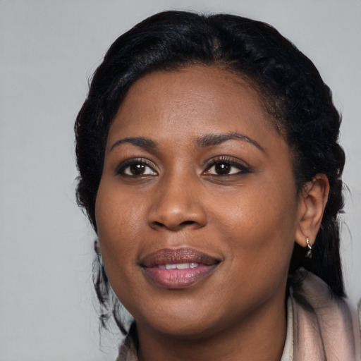Joyful black young-adult female with long  black hair and brown eyes