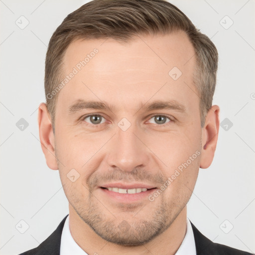 Joyful white young-adult male with short  brown hair and grey eyes