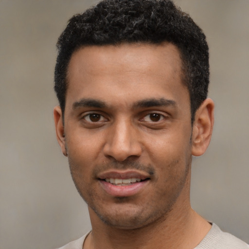 Joyful black young-adult male with short  black hair and brown eyes