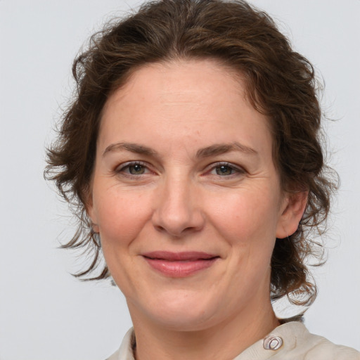 Joyful white adult female with medium  brown hair and grey eyes