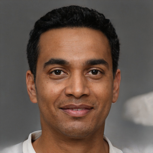 Joyful black young-adult male with short  black hair and brown eyes