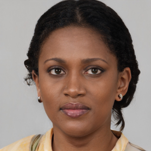 Joyful black young-adult female with short  brown hair and brown eyes