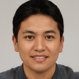 Joyful asian young-adult male with short  black hair and brown eyes