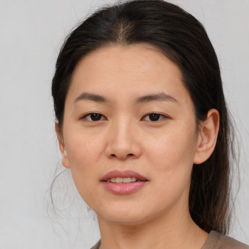Joyful asian young-adult female with medium  brown hair and brown eyes