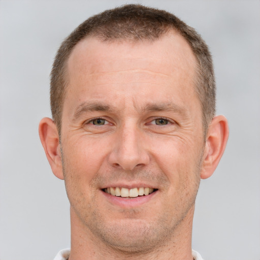 Joyful white adult male with short  brown hair and brown eyes