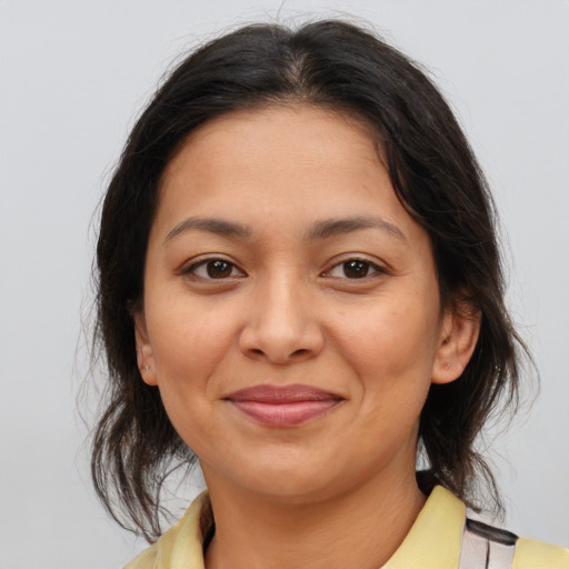 Joyful latino young-adult female with medium  brown hair and brown eyes